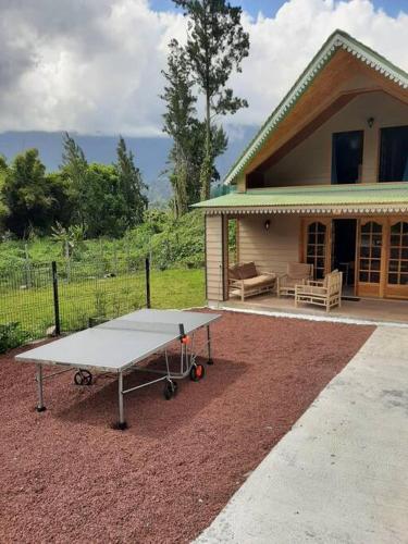 a ping pong table in front of a house at Chalet de la Mare. in Salazie