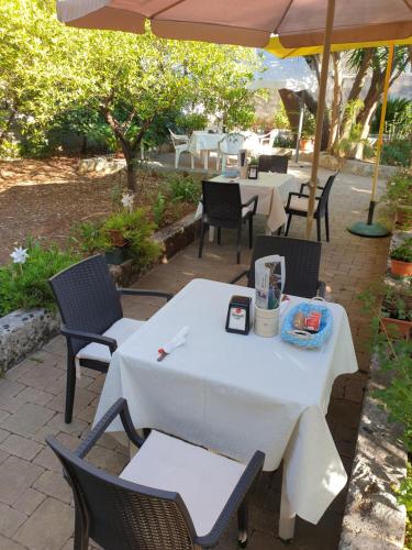 a white table and chairs under an umbrella at B&B Pittoresco in Specchia
