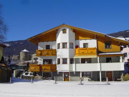 a building with a wooden roof in the snow at Appartement Pichler in Radstadt