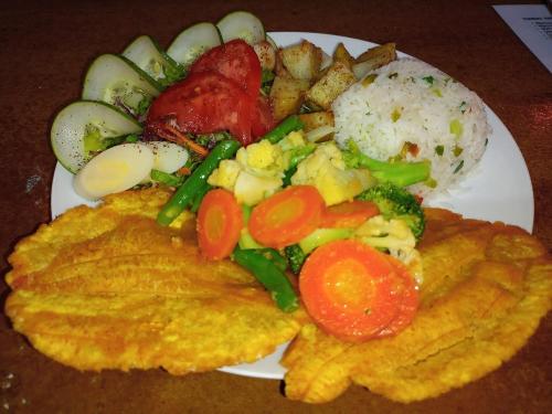 a plate of food with eggs rice and vegetables at The Sweet Escape Cabinas in Sierpe