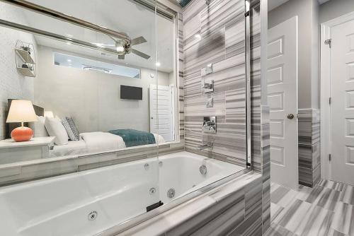 a white bathroom with a tub and a window at HostWise Stays - The Washington at Chatham - Park Free, Gym, More! in Pittsburgh