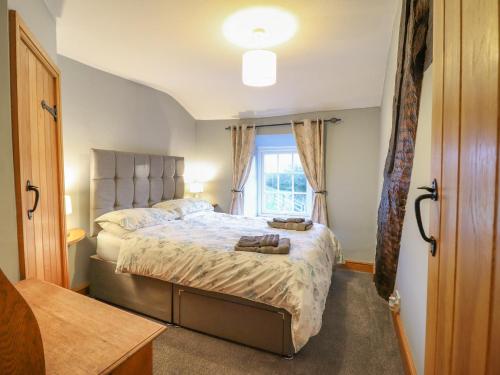 a bedroom with a large bed with a window at Ynys in Dyffryn