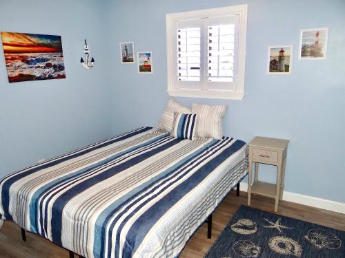 a blue bedroom with a bed and a window at 17A GCR Lovely 2 bed Condo with pool in Surfside in Myrtle Beach