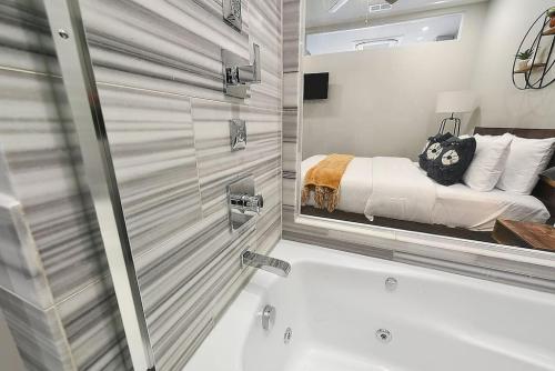 a bathroom with a tub and a bed and a mirror at HostWise Stays - The Washington at Chatham - Free Garage Parking across from PPG Arena in Pittsburgh