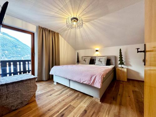a bedroom with a bed and a large window at Mountain Lodge Sölden - Ski in Bike out Chalet in Sölden