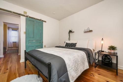 a bedroom with a bed and a blue door at HostWise Stays - The Ocala - Free Parking, Cool Space, Spiral Stairs in Pittsburgh