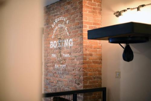 a brick wall with an old sign on it at HostWise Stays - The Ocala - Free Parking, Cool Space, Spiral Stairs in Pittsburgh