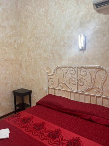 a bedroom with a bed with a red bedspread at Roma Guest House in Rome