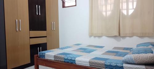 um quarto com uma cama com um cobertor xadrez em Apartamento em Cabo Frio com Wi-fi em Cabo Frio
