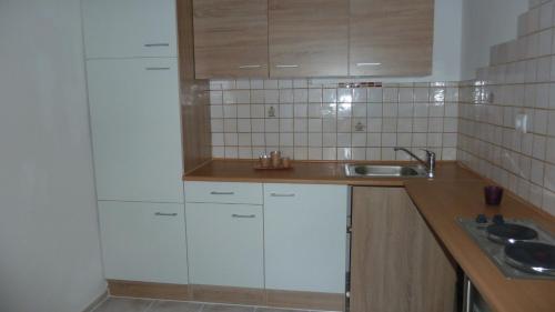 a kitchen with white cabinets and a sink at Lemmerer Homestay in Sankt Lorenzen bei Knittelfeld