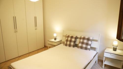 niewielka sypialnia z białym łóżkiem i 2 szafkami nocnymi w obiekcie Casa Nadia w mieście Guardistallo