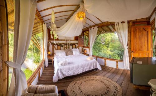 - une chambre dans une cabane dans les arbres avec un lit dans l'établissement LA GRANJA ECOHOTEL, à La Tebaida