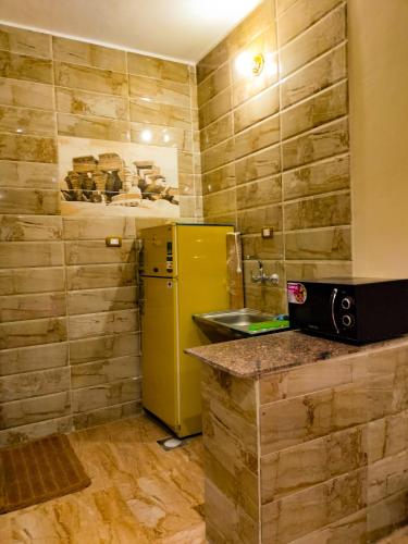 a kitchen with a yellow refrigerator and a sink at Safari Abu Simbel in Abu Simbel