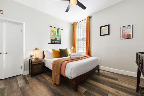 a bedroom with a bed and a ceiling fan at HostWise Stays - The Grandview - Great City Views - Brand New Remodel in Pittsburgh