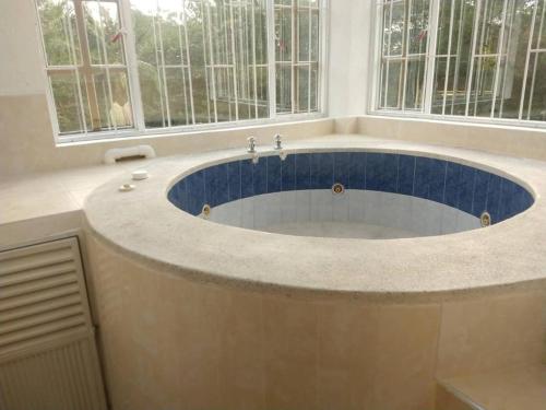 a large bath tub in a bathroom with windows at paraiso in Fusagasuga