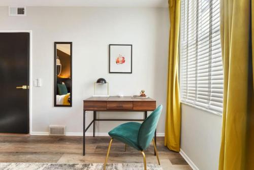 a room with a desk and a green chair at HostWise Stays - Grandview Balcony with Stunning Skyline Views in Pittsburgh