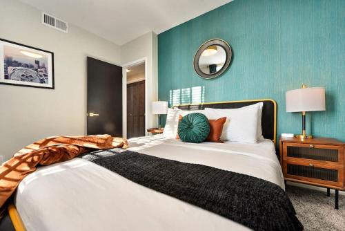 een slaapkamer met een groot bed met een blauwe muur bij HostWise Stays - Grandview Balcony with Stunning Skyline Views in Pittsburgh