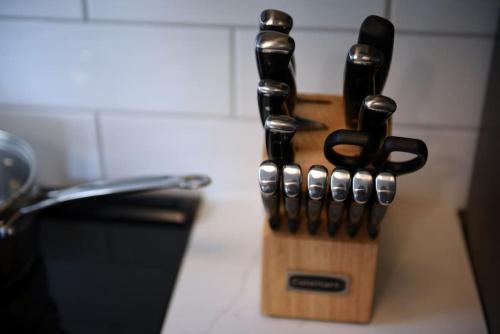 a wooden knife block with four knives on a counter at HostWise Stays - Grandview Balcony with Stunning Skyline Views in Pittsburgh