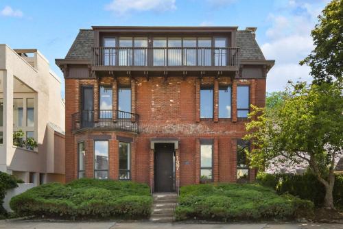 a brick house with a balcony on top of it at HostWise Stays - Grandview Balcony with Stunning Skyline Views in Pittsburgh