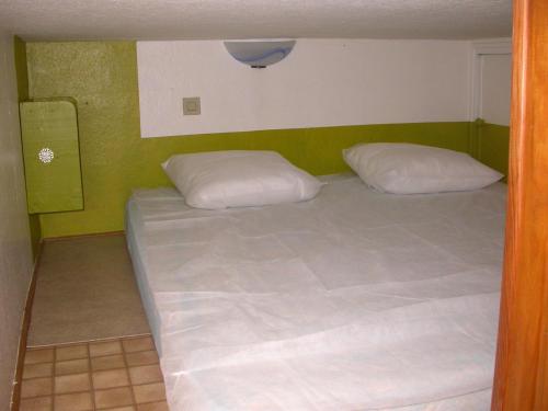 a bed in a room with two white pillows at Appartement Résidence Napoléon in Cauterets
