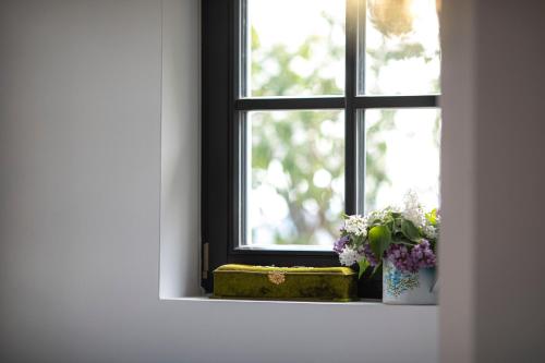 a window with a vase of flowers on a window sill at Nagykulcsos Nyúlontúl in Mencshely