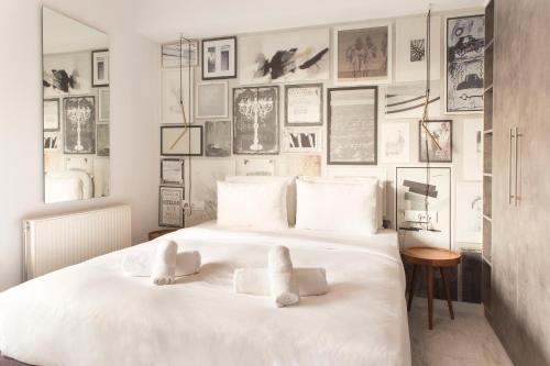 1 dormitorio con 1 cama blanca con cuadros en la pared en Luxury Apartment near Acropolis-Living Stone Gold, en Atenas