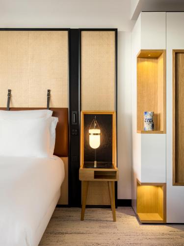 a bedroom with a bed and a lamp on a table at FirstName Bordeaux, Part of JdV by Hyatt in Bordeaux