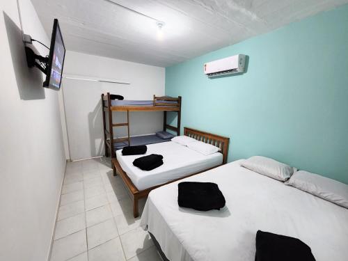 Habitación pequeña con 2 camas y escritorio. en Cantinho residencial en Maresias