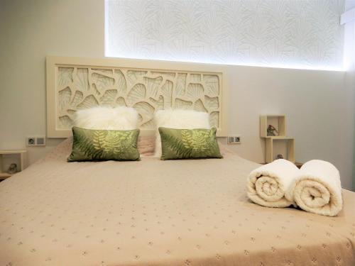 een slaapkamer met een groot bed en handdoeken bij Romántico estudio centro de Algeciras in Algeciras