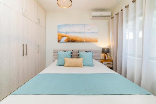 a bedroom with a bed with blue pillows at Beachcove Apt No 10 in Pereybere