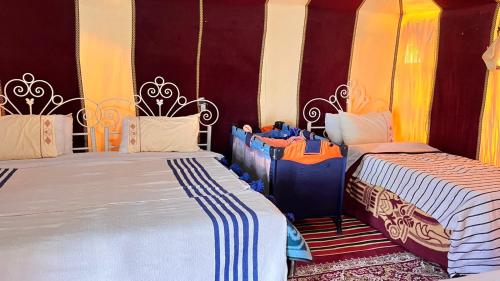 two beds in a room with two at Sahara Luxury Camp in Zagora