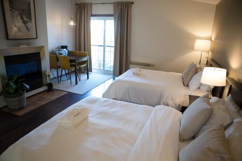 - une chambre d'hôtel avec 2 lits et une cheminée dans l'établissement Le Montagnard, Auberge Hôtel & Chalets, à Sutton