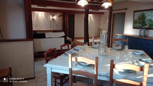 a dining room table with a white table cloth and chairs at Maison de ferme au calme jusqu'à 10 personnes in Gannay-sur-Loire