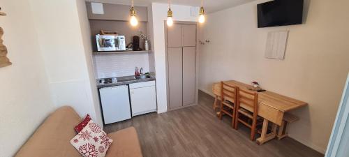 Ce petit appartement comprend une table et une cuisine. dans l'établissement Appartement chaleureux, Gourette Pieds des pistes, à Gourette