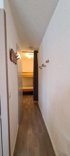 un couloir avec une chambre dotée d'un lit dans l'établissement Appartement chaleureux, Gourette Pieds des pistes, à Gourette
