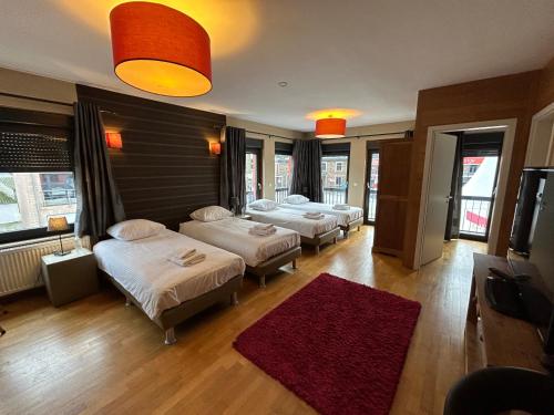 a room with four beds and a red rug at Race & Rooms in Francorchamps