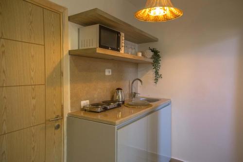 a small kitchen with a sink and a microwave at BIRD NEST Near Arkan Plaza in Cairo