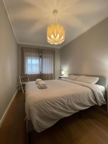 a bedroom with a large bed and a chandelier at Lindo apartamento em Gaia ao lado Bodegas in Vila Nova de Gaia