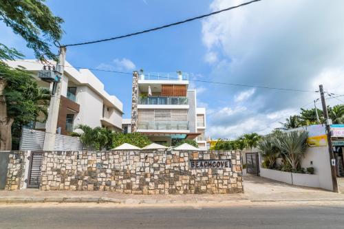 a building behind a stone wall with a sign on it at Beachcove in Pereybere