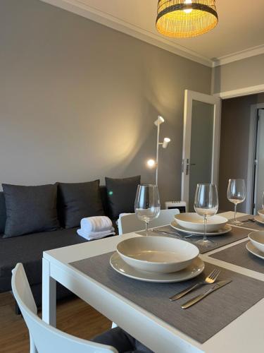 a dining room with a table with plates and wine glasses at Lindo apartamento em Gaia ao lado Bodegas in Vila Nova de Gaia