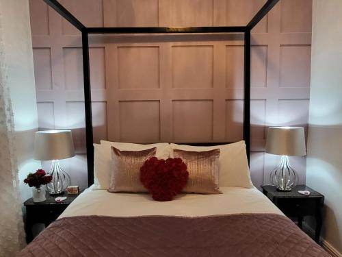 Un dormitorio con una cama con un corazón rojo. en Prosecco Palace, en York
