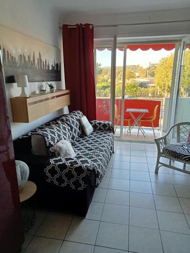 - un salon avec un canapé et une vue sur une terrasse dans l'établissement Studio de l'hippodrome, à Cagnes-sur-Mer