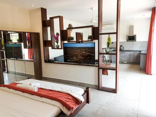 een woonkamer met een flatscreen-tv aan de muur bij Kasumai Beach Resort in Bijilo