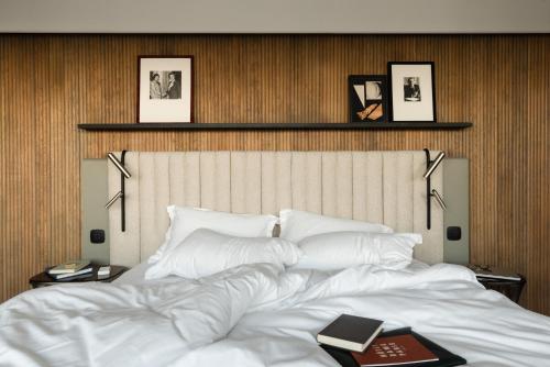 a bedroom with a large white bed with books on it at Hôtel Dame des Arts in Paris