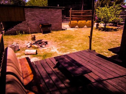 un banco de madera sentado en una terraza en un patio en Cabaña en el Bosque de la Viuda, en Punta del Diablo