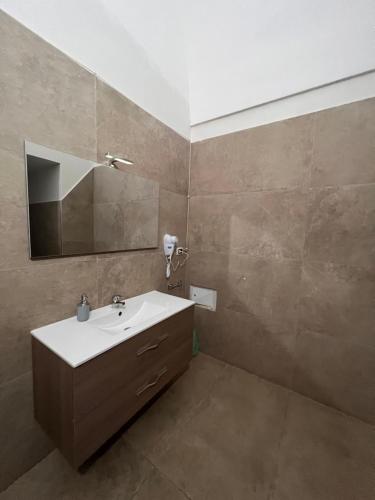 ein Bad mit einem Waschbecken und einem Spiegel in der Unterkunft B&B Appia Antica in Massafra