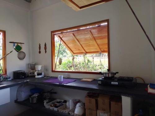 a kitchen with a counter with a window in it at Cabaña Caporo - privada con ubicación central in Acanti
