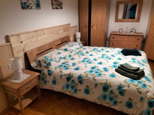 Un dormitorio con una cama con flores azules. en AJARNOLA N14, en Padola