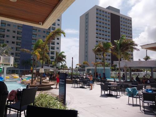 a resort patio with tables and chairs and buildings at Salinas exclusive Ary Costa in Salinópolis