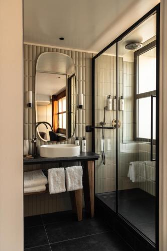 a bathroom with a sink and a mirror at Hôtel Dame des Arts in Paris